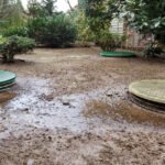 The outside of a house with sewage seeping into the yard due to a problem with the underground septic system.